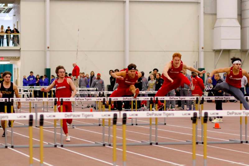 a group of people jumping over hurdles