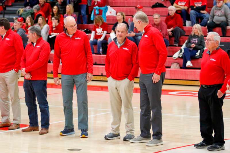 a group of men in red shirts standing on a court