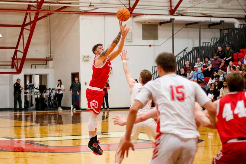 a basketball player in a red uniform jumping to block a ball