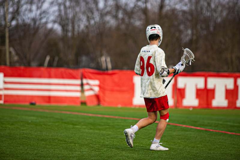 a person wearing a helmet and holding a lacrosse stick