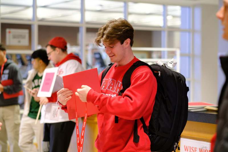a man in a red sweatshirt holding a red piece of paper