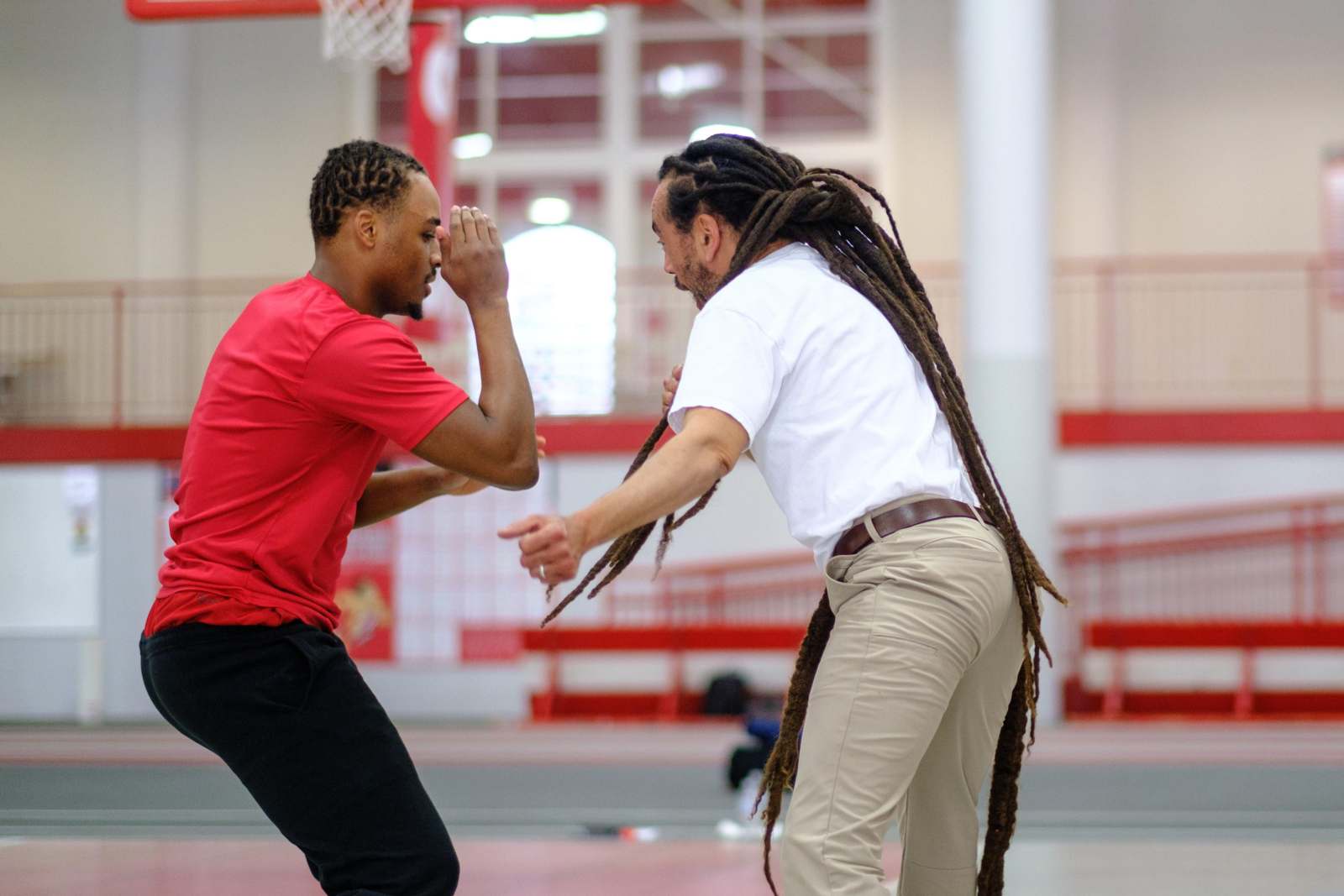 a man with long dreadlocks holding another man's face