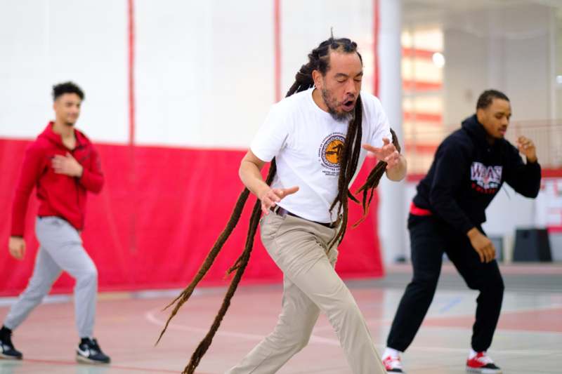 a man with long dreadlocks dancing on a court