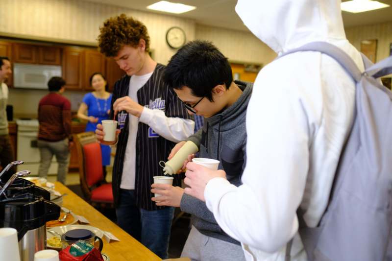 a group of people pouring coffee into cups