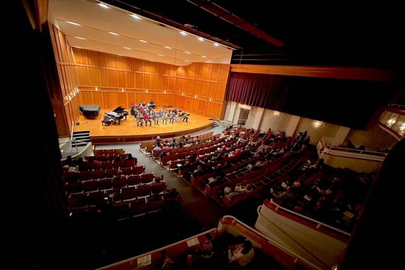 a group of people on a stage in a concert hall