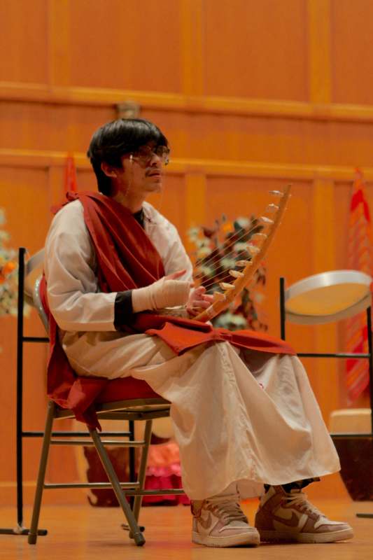 a man in a red robe playing a string instrument