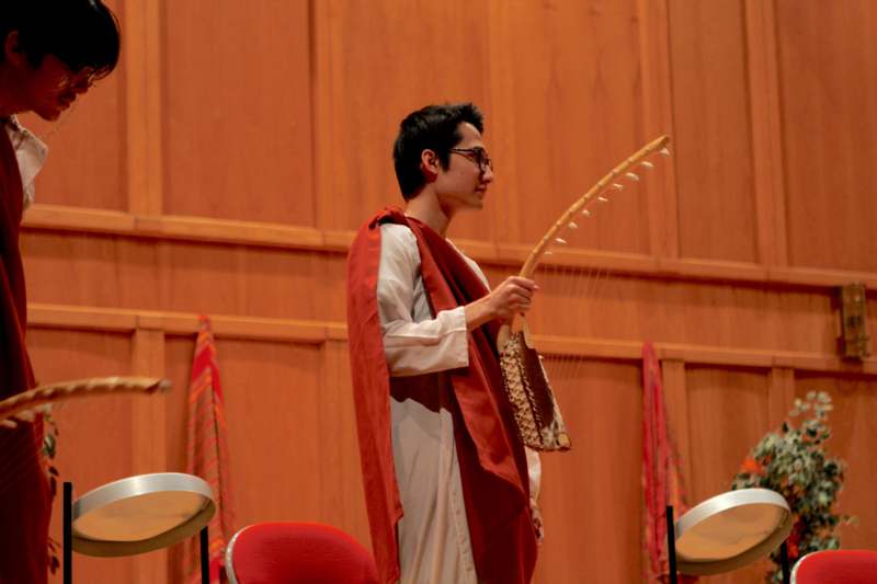 a man in a robe playing a musical instrument