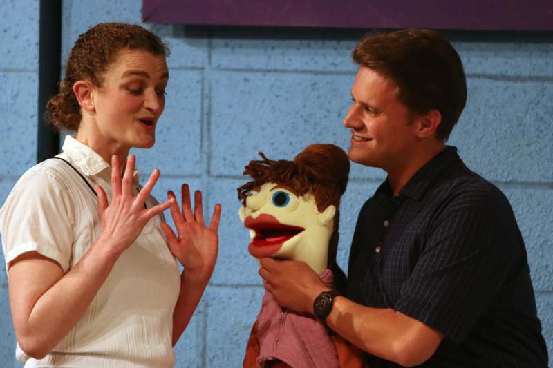 a man and woman holding a puppet