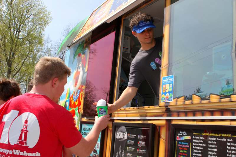 a man standing in a window of a food truck