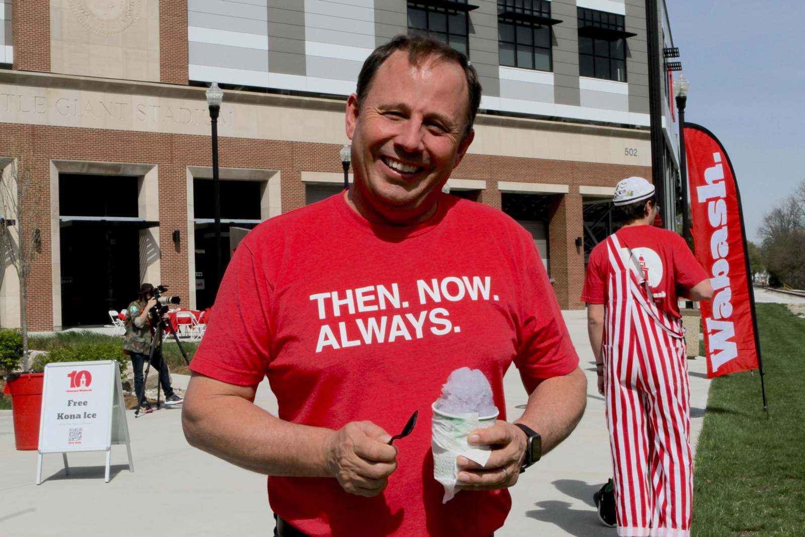 a man in a red shirt holding a spoon and ice cream