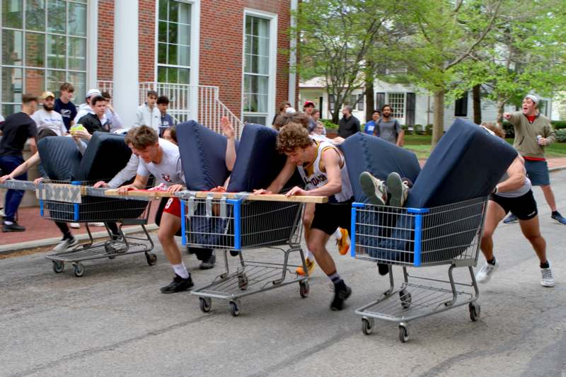 a group of people pushing shopping carts with mattresses
