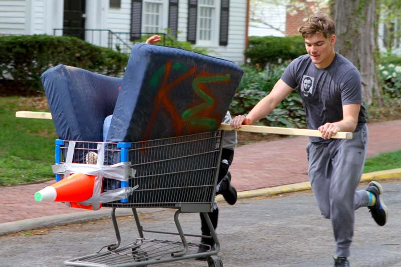 a man pushing a shopping cart with furniture