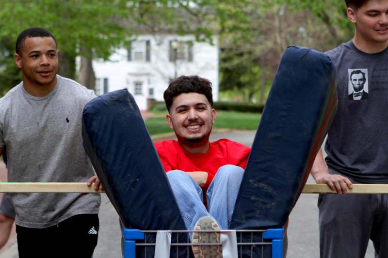 a man sitting in a cart with two people behind him