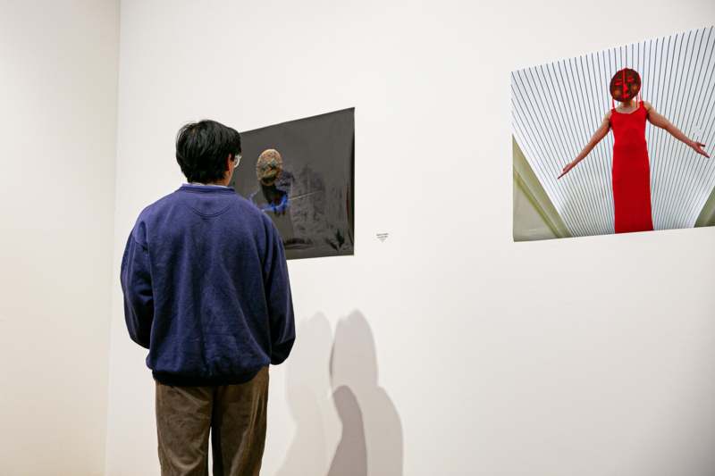 a man looking at a picture on a wall