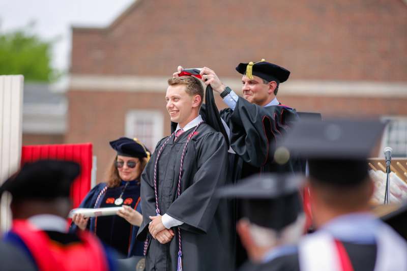 a man putting on a graduation cap