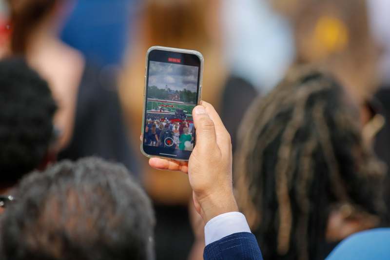 a person holding a phone with a picture of a crowd