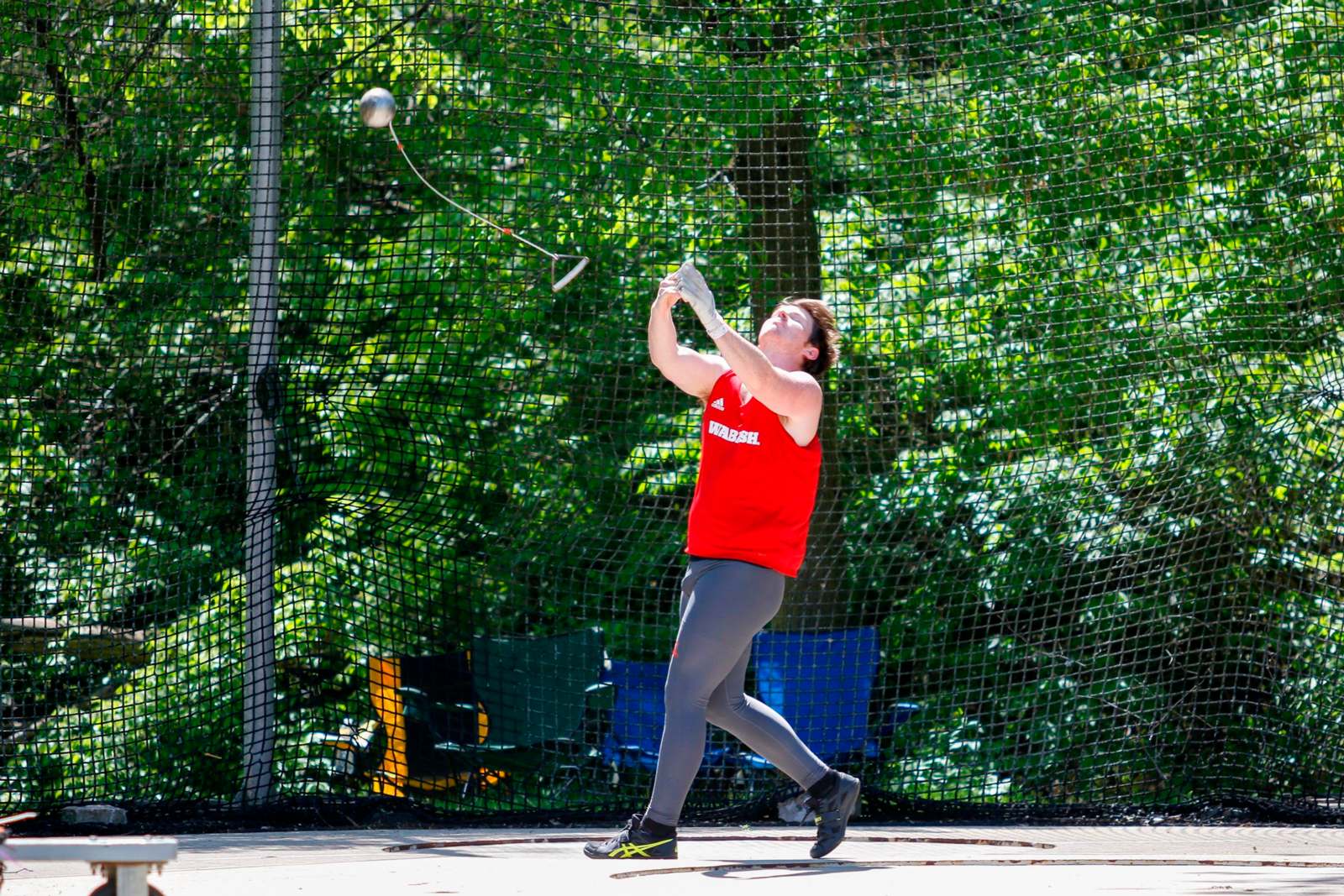 a person in a red shirt hitting a ball with a ball