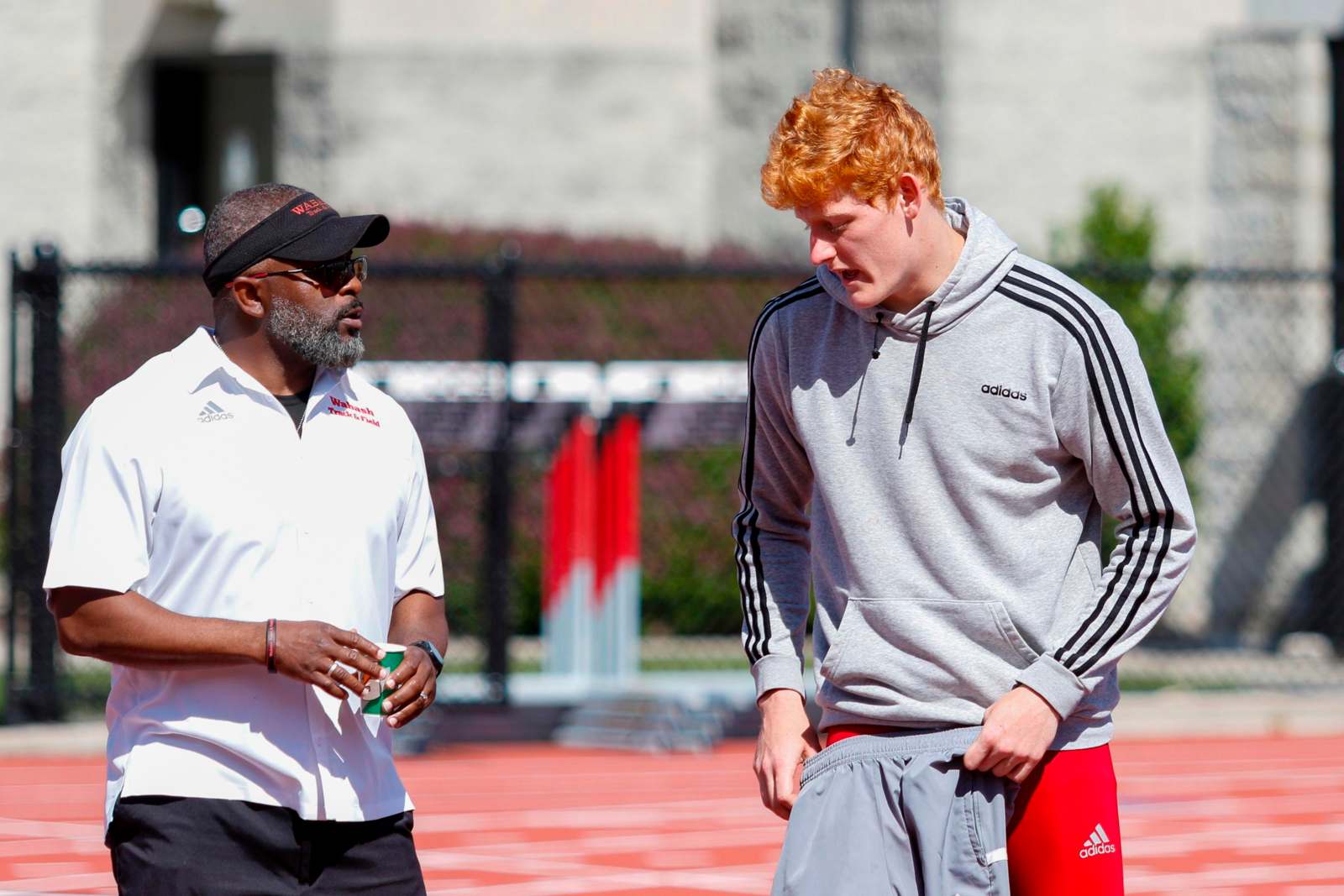 a man talking to another man on a track