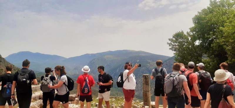 a group of people standing on a rock looking at a mountain range