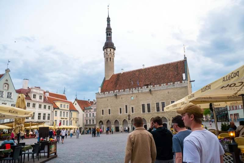 people walking in a square with a tall tower