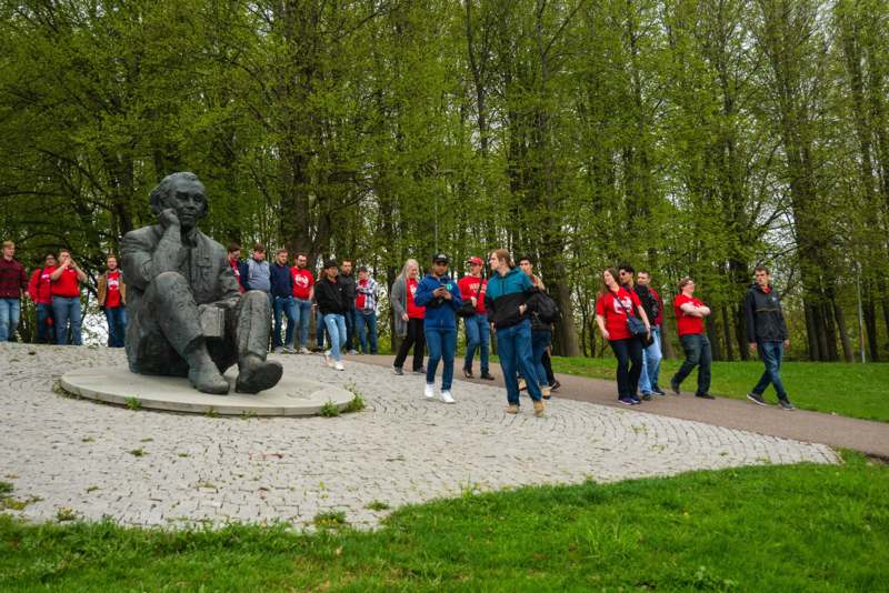 a group of people walking around a statue