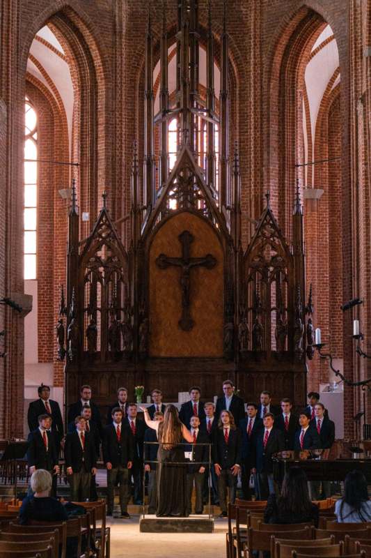a group of people in suits standing in front of a large church
