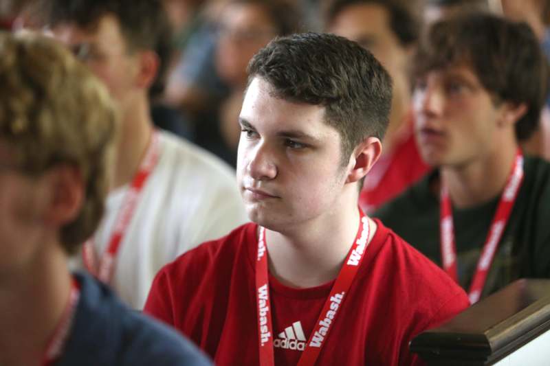 a man wearing a red shirt and lanyard