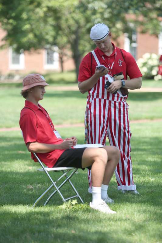 a man in red and white striped outfit sitting in a chair with a man in red and white striped outfit