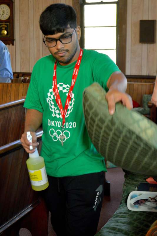 a man in a green shirt holding a bottle and a spray bottle