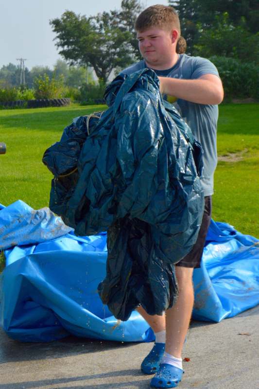 a man holding a large blue tarp