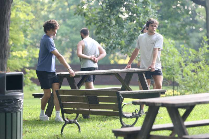 a group of men standing around a picnic table