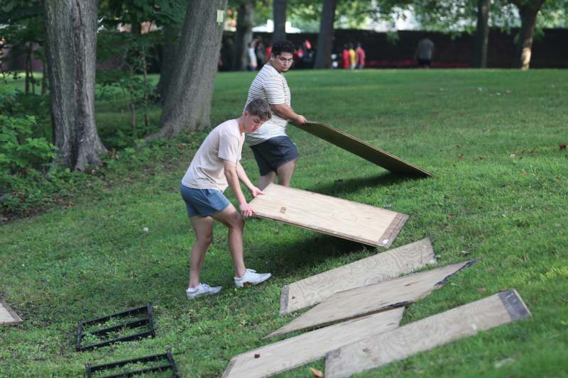 two men holding boards in a park