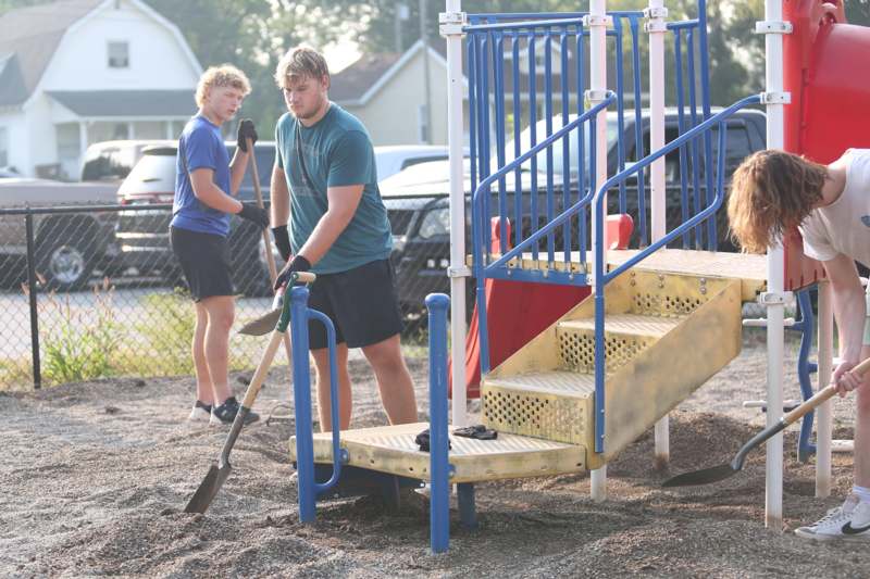 two men digging in a playground
