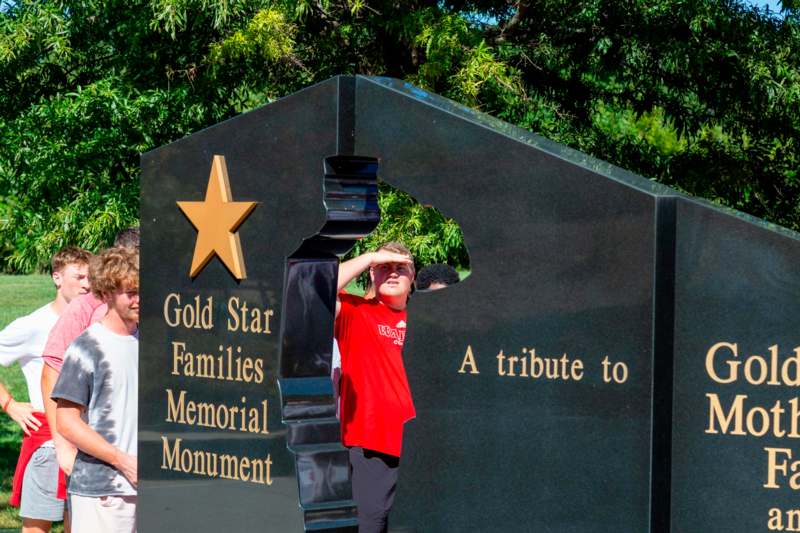 a boy standing in front of a memorial