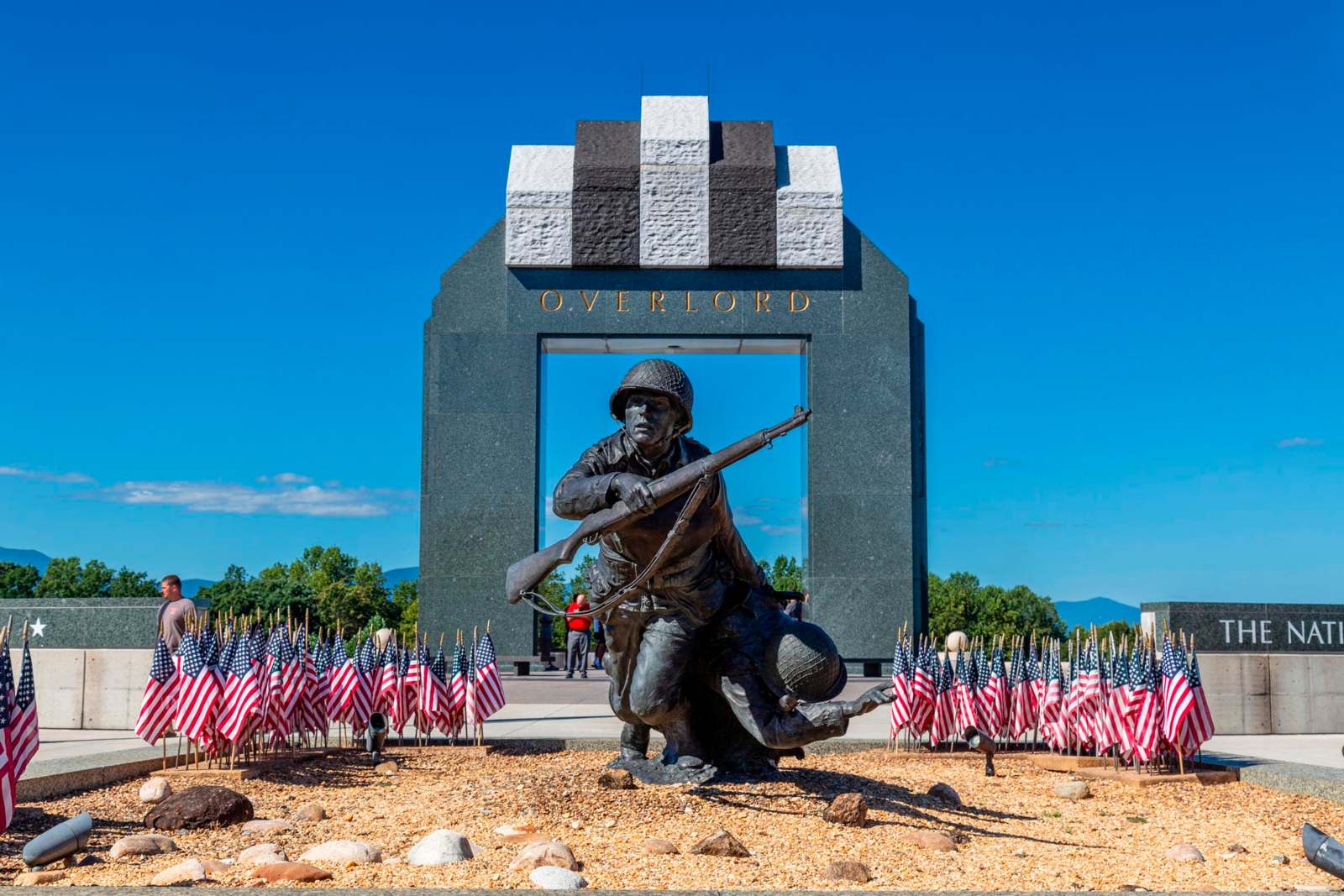 a statue of a soldier holding a rifle in front of a memorial