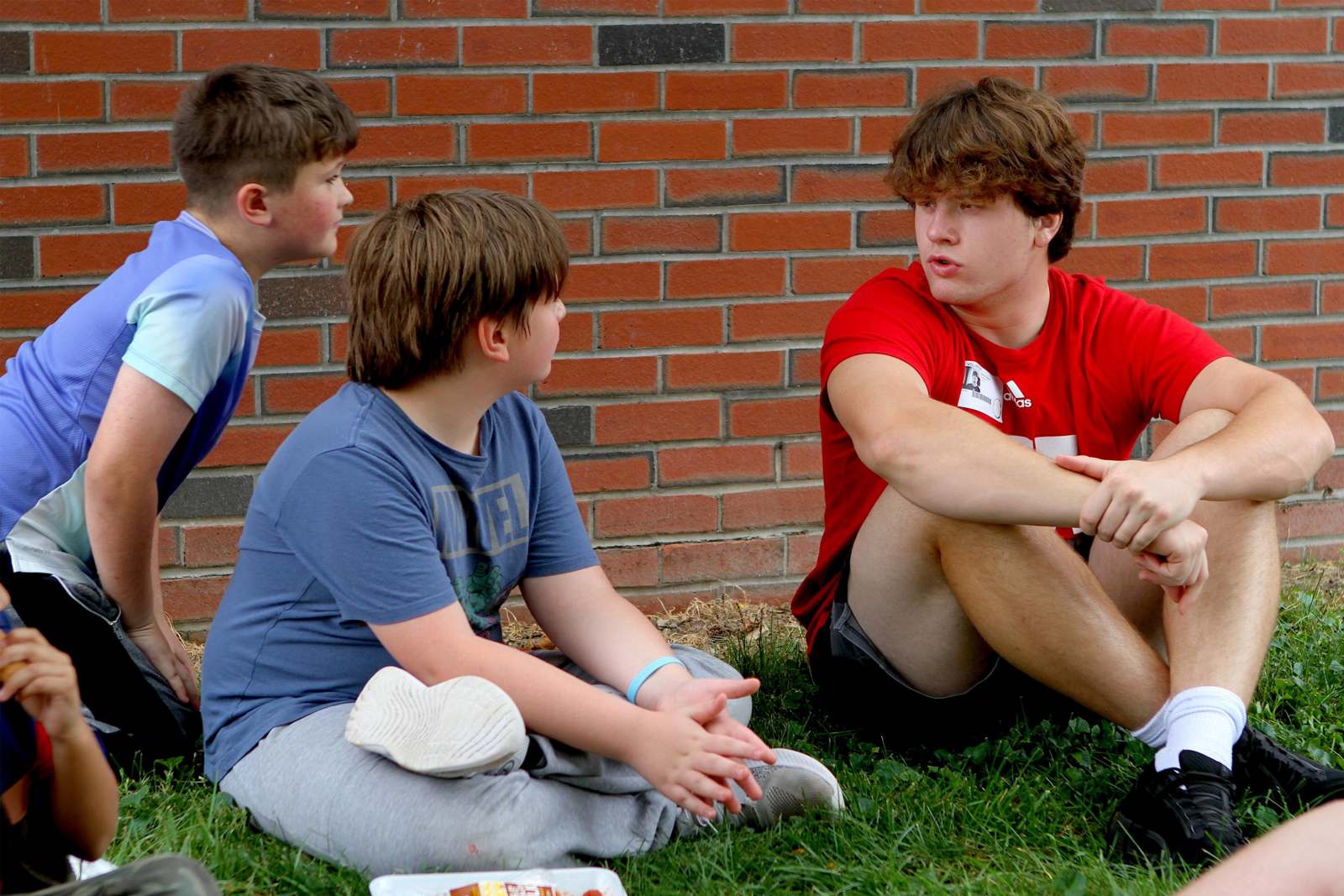 a group of boys sitting on grass