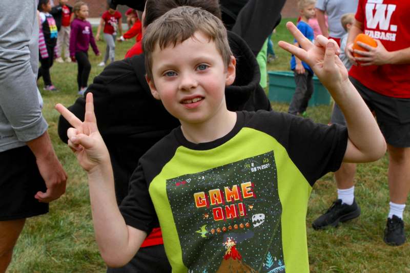 a boy making a peace sign with his hands