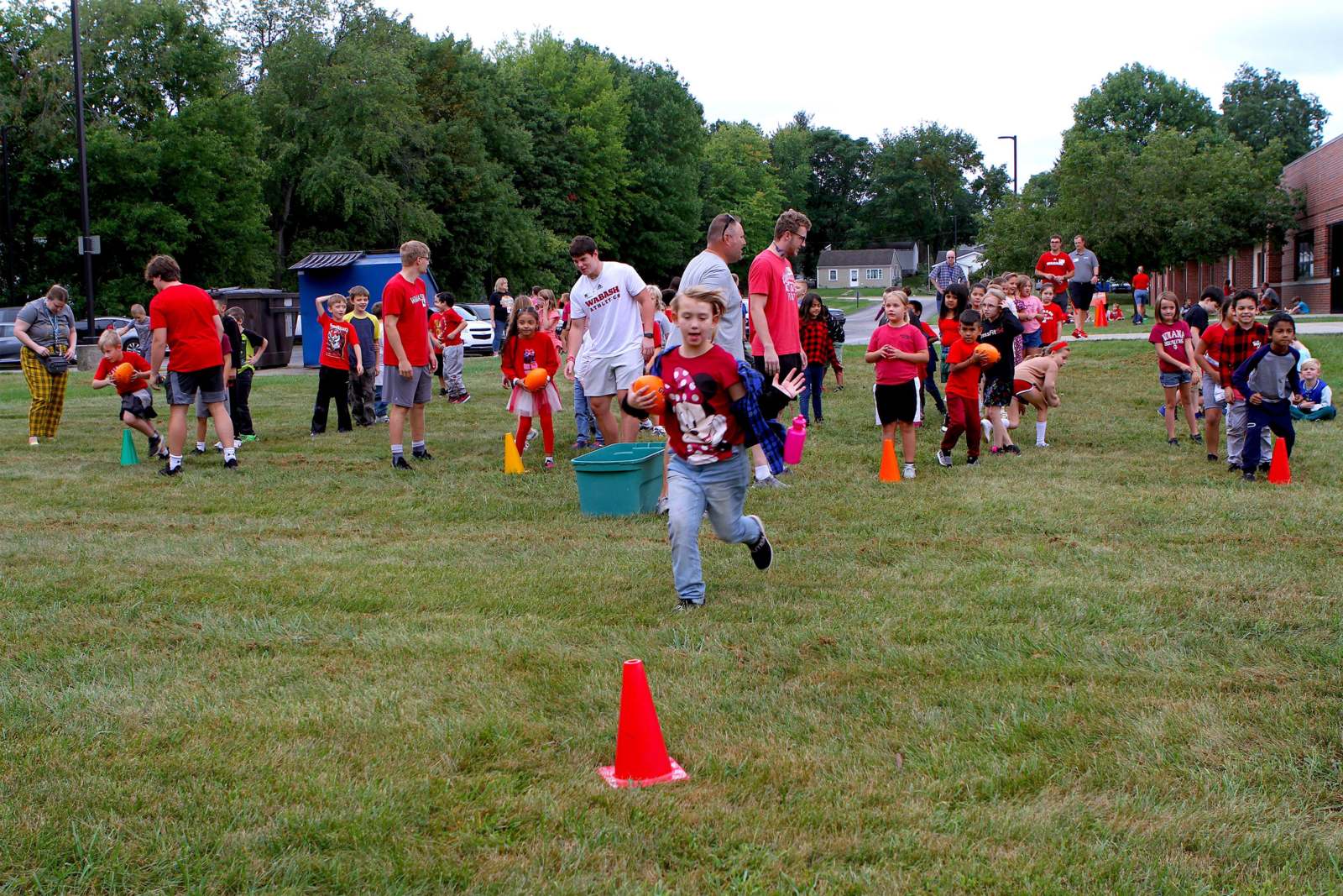 a group of kids running in a field