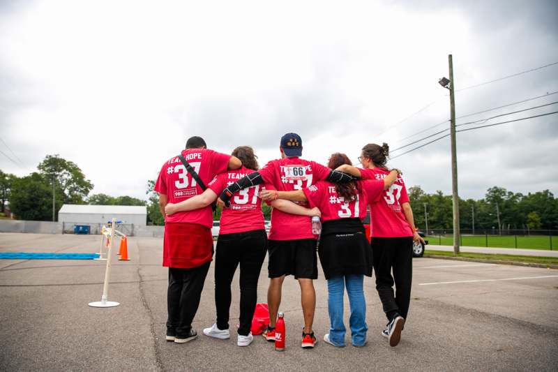 a group of people in red shirts hugging