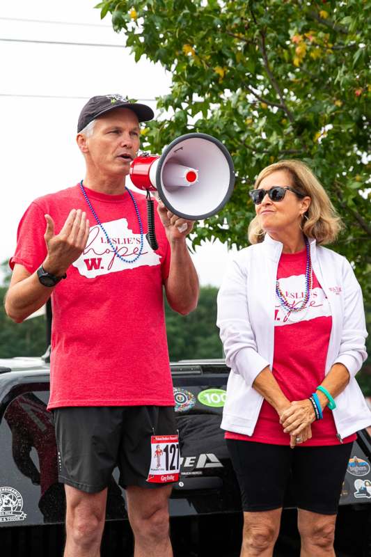 a man and woman in red shirts speaking into a megaphone