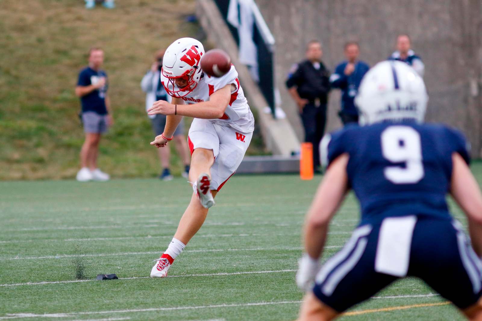 a football player in a helmet kicking a football
