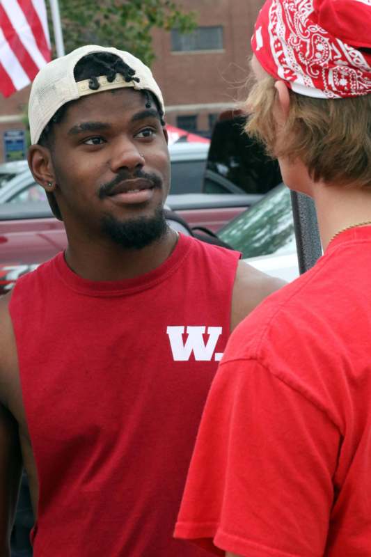 a man in a red tank top and white hat