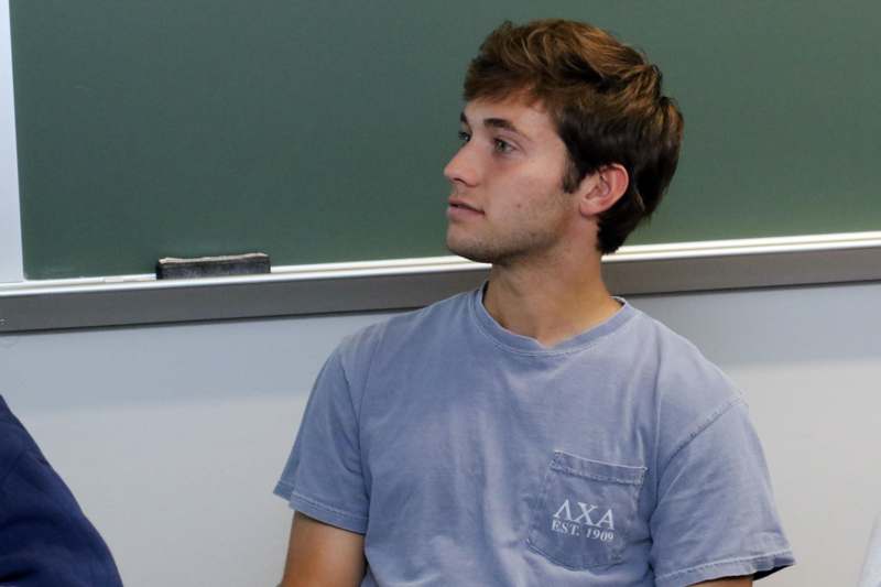a man sitting in front of a chalkboard