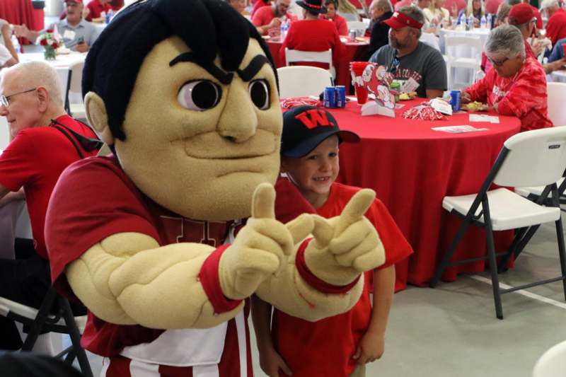a boy in a red shirt with a mascot