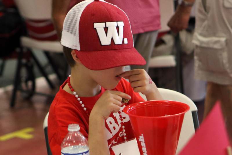a boy wearing a red hat and eating