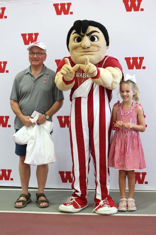 a man and girl posing with a mascot