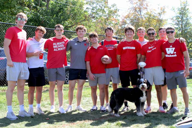 a group of men in red shirts and a dog