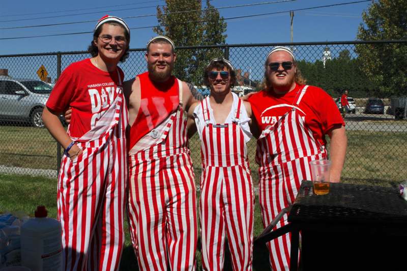 a group of men wearing striped overalls and red shirts