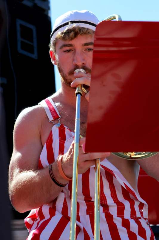 a man in a red and white striped outfit playing a trumpet