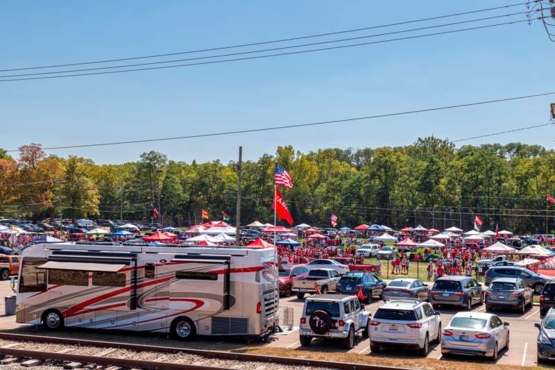 a large parking lot with a large crowd of people and a rv